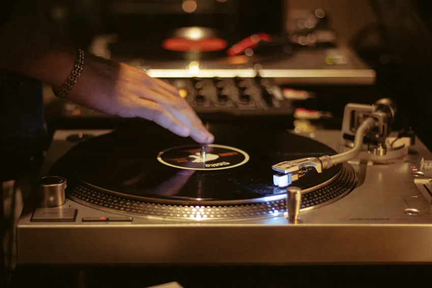 DJ con bandeja de vinilos en un evento en SĀNTAL