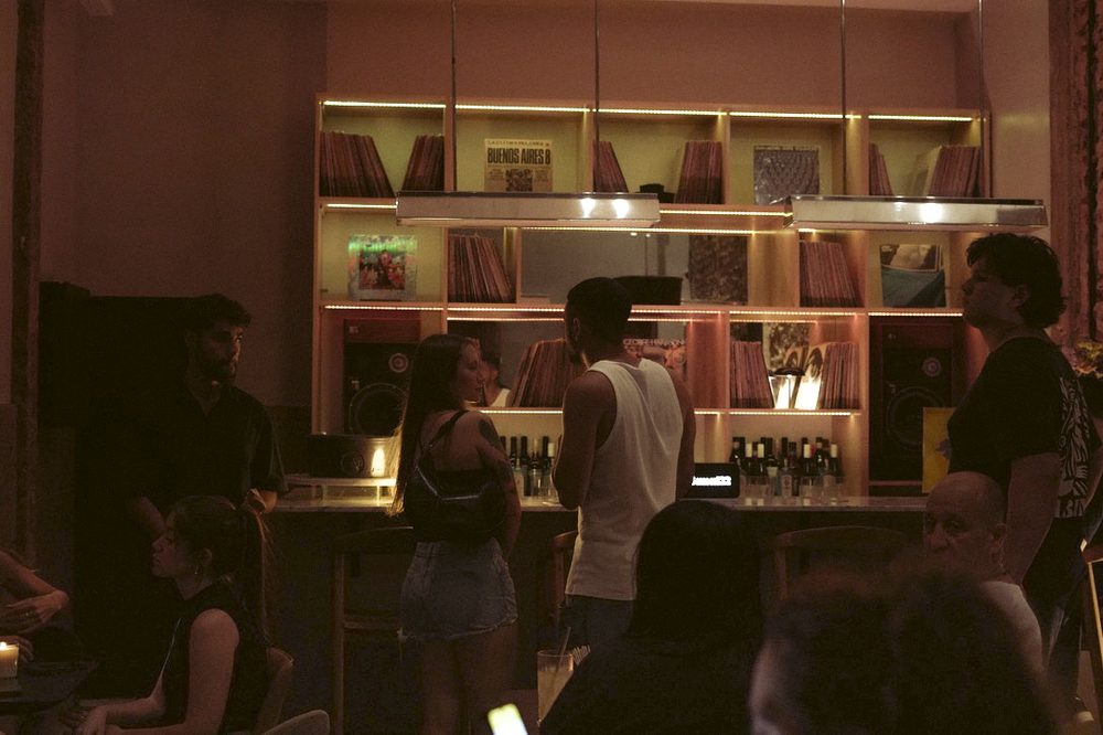 Gente conversando frente a la barra de discos durante un viernes de vinilos en Colegiales