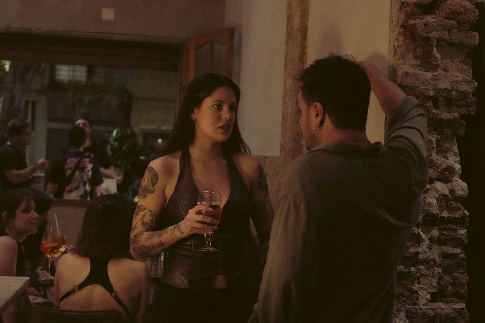 Pareja conversando junto a la pared de ladrillo a la vista en el bar de escucha de Colegiales