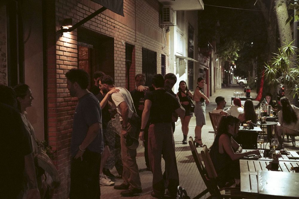 Vereda llena de gente un viernes a la noche frente a SĀNTAL Colegiales en el barrio de Colegiales